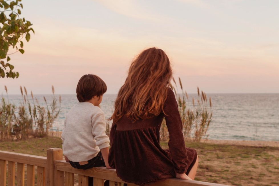 Madre e figlio osservano il mare in orizzonte riflettendo sul loro rapporto